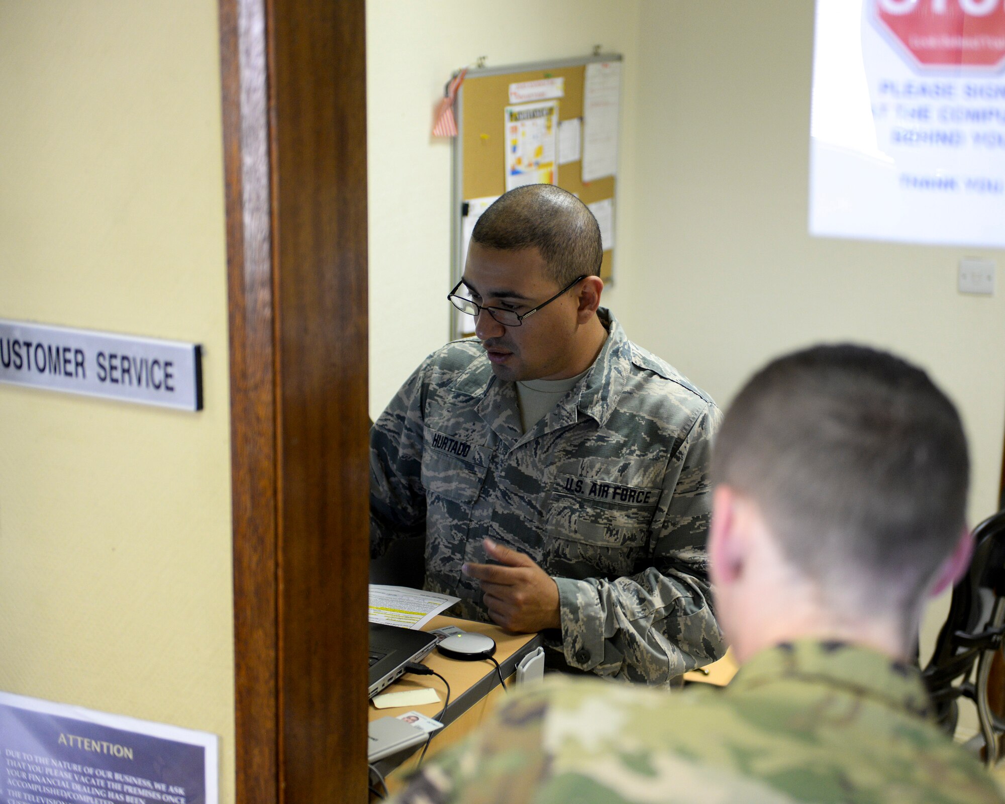 U.S. Air Force Senior Airman Andres Hurtado, cashier assigned to the 379th Expeditionary Comptroller Squadron, Financial Services Flight, assists a customer at Al Udeid, Air Base, Qatar, June 13, 2017. The FMF assists deployed military members with travel pay, military pay and dispersal of funds. (U.S. Air National Guard photo by Tech. Sgt. Bradly A. Schneider/Released)