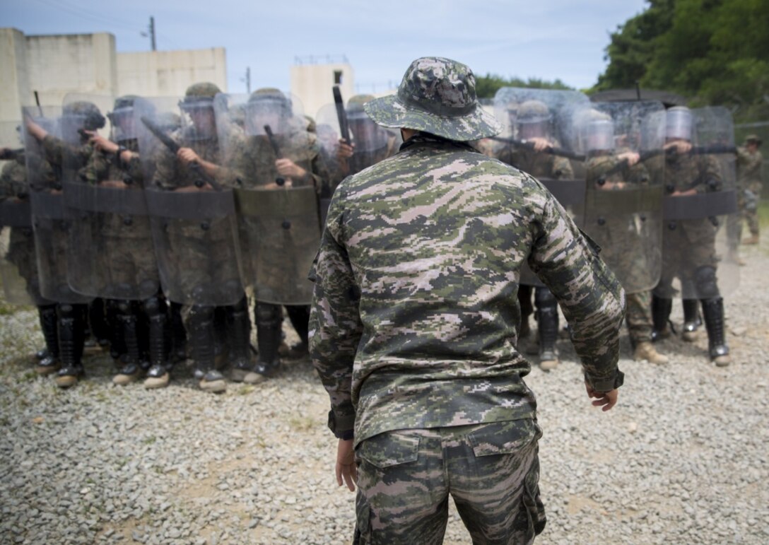 A Republic of Korea Marine attempts to break through a riot control line during riot control training, at Pohang, South Korea, June 22, 2017. ROK Marines simulated rioters by attempting to break through the riot control line as defenders subdued the aggressors. U.S. and ROK Marines practice their non-lethal force tactics during Korean Marine Exchange Program 17-7. KMEP 17-7 is just one of the many opportunities made possible for ROK and U.S. Marines to learn and train with one another. The U.S. Marines are military policemen with Bravo Company, 3rd Law Enforcement Battalion, III Marine Expeditionary Force. (U.S. Marine Corps photo by Lance Cpl. Andy Martinez) 