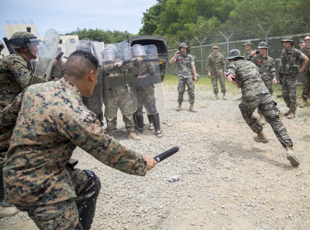 Military police Marines with Bravo Company, 3rd Law Enforcement Battalion, III Marine Expeditionary Force, break formation to detain the remaining Republic of Korea Marine during riot control training, at Pohang, South Korea, June 22, 2017. ROK Marines simulated rioters by attempting to break through the riot control line as defenders subdued the aggressors. U.S. and ROK Marines practice their non-lethal force tactics during Korean Marine Exchange Program 17-7. KMEP 17-7 is just one of the many opportunities made possible for ROK and U.S. Marines to learn and train with one another. (U.S. Marine Corps photo by Lance Cpl. Andy Martinez) 