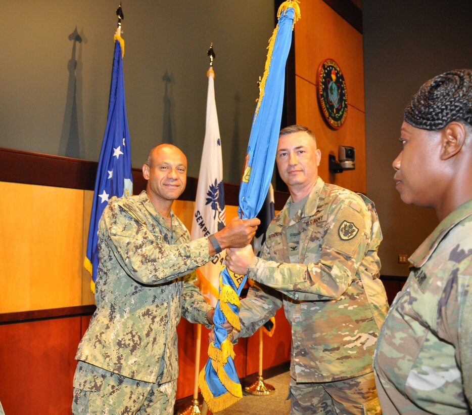Navy Rear Adm. Vincent Griffith (left), then DLA Director of Logistics Operations, passes the flag to the new DLA CENTCOM & SOCOM commander, Army Col. Archie Herndon, at MacDill Air Force Base, Florida, July 7.  
 