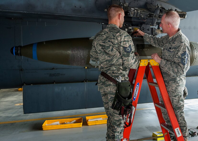 (From right) Chief Master Sgt. Alan Boling, Eighth Air Force command chief, speaks with Tech. Sgt. Cory Erickson, 5th Maintenance Group load standardization crew member, beneath a B-52H Stratofortress wing at Minot Air Force Base, N.D., July 10, 2017. Boling participated in a GBU-31V1 bomb load and was inducted as an honorary B-52 weapons loader. (U.S. Air Force photos/Senior Airman J.T. Armstrong)