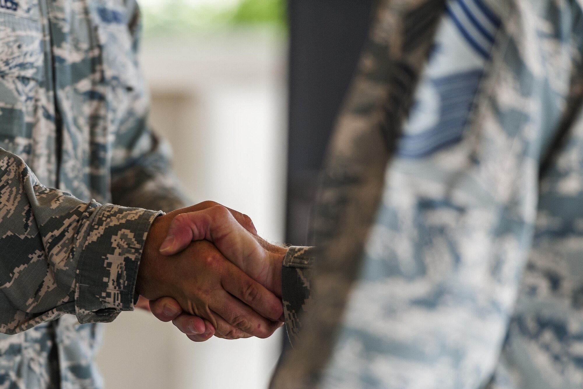 Chief Master Sgt. Alan Boling, Eighth Air Force command chief, coins a 5th Security Forces Squadron Airman at Minot Air Force Base, N.D., July 11, 2017. During his visit, Boling spoke with 5th Bomb Wing Airmen and visited facilities including the fire department, weapons loading dock, bomb building facility, dining facility and parachute shop. (U.S. Air Force photos/Senior Airman J.T. Armstrong)