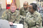 Chief Warrant Officer 3 Christopher Pruitt, Joint Force Headquarters North Carolina, demonstrates the tracking of the Soldier Readiness Process recording system to VING Adjutant General Deborah Howell on July 15, 2017. SRP is being conducted to ensure Soldiers' records are up to date for the new personnel and pay system IPPS-A. 