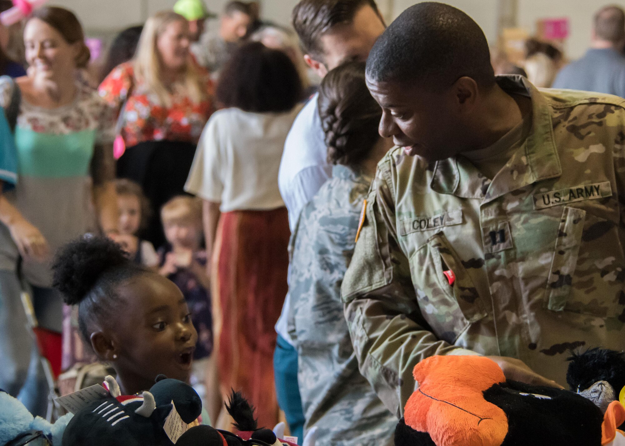 A girl is excited by a toy a U.S. Army captain picked up from one of the tables at the Military Kids Appreciation Day at Dobbins Air Reserve Base, Ga. July 9, 2017. The 94th Airlift Wing partnered with the Kids Wish Network, a national children’s charity, to host the event that supported Dobbins military members and their children. (U.S. Air Force photo by Staff Sgt. Andrew Park)
