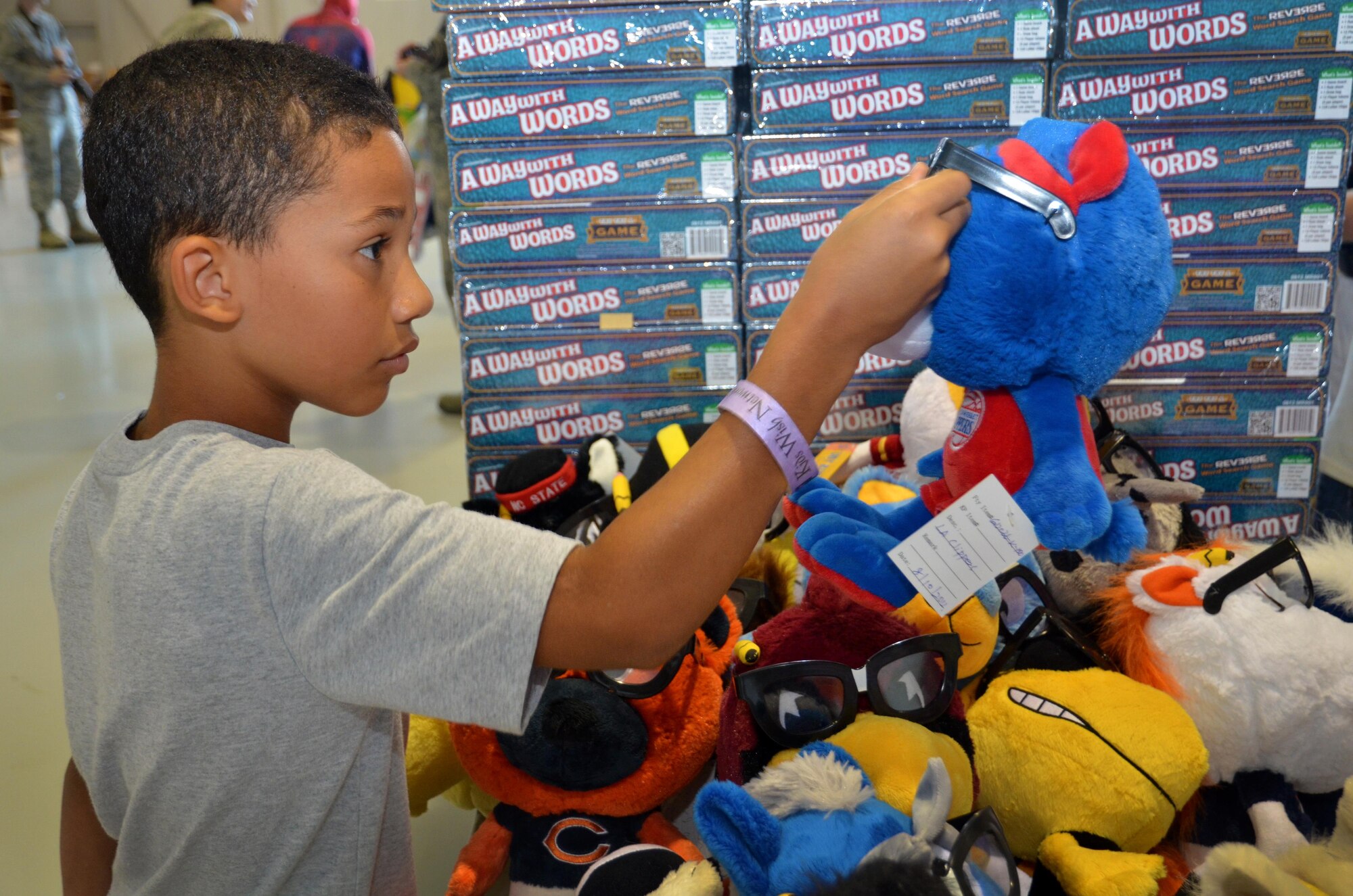 A child looks at a stuffed animal at the Military Kids Appreciation Day at Dobbins Air Reserve Base, Ga. July 9, 2017. Kids Wish Network brought new toys, educational items, games and other necessities for service members’ children. (U.S. Air Force photo by Senior Airman Lauren Douglas)