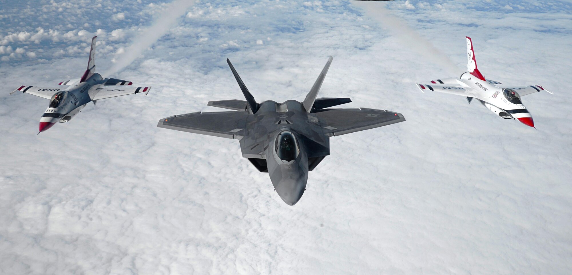 Two U.S. Air Force Thunderbirds and an F-22 Raptor, assigned to the Air Combat Command F-22 Demonstration Team, Langley Air Force Base, Virginia, fly in formation July 14, 2017, after aerial refueling over France. The flight was on their way to the 2017 Royal International Air Tattoo airshow at RAF Fairford, England. (U.S. Air Force photo by Senior Airman Justine Rho)