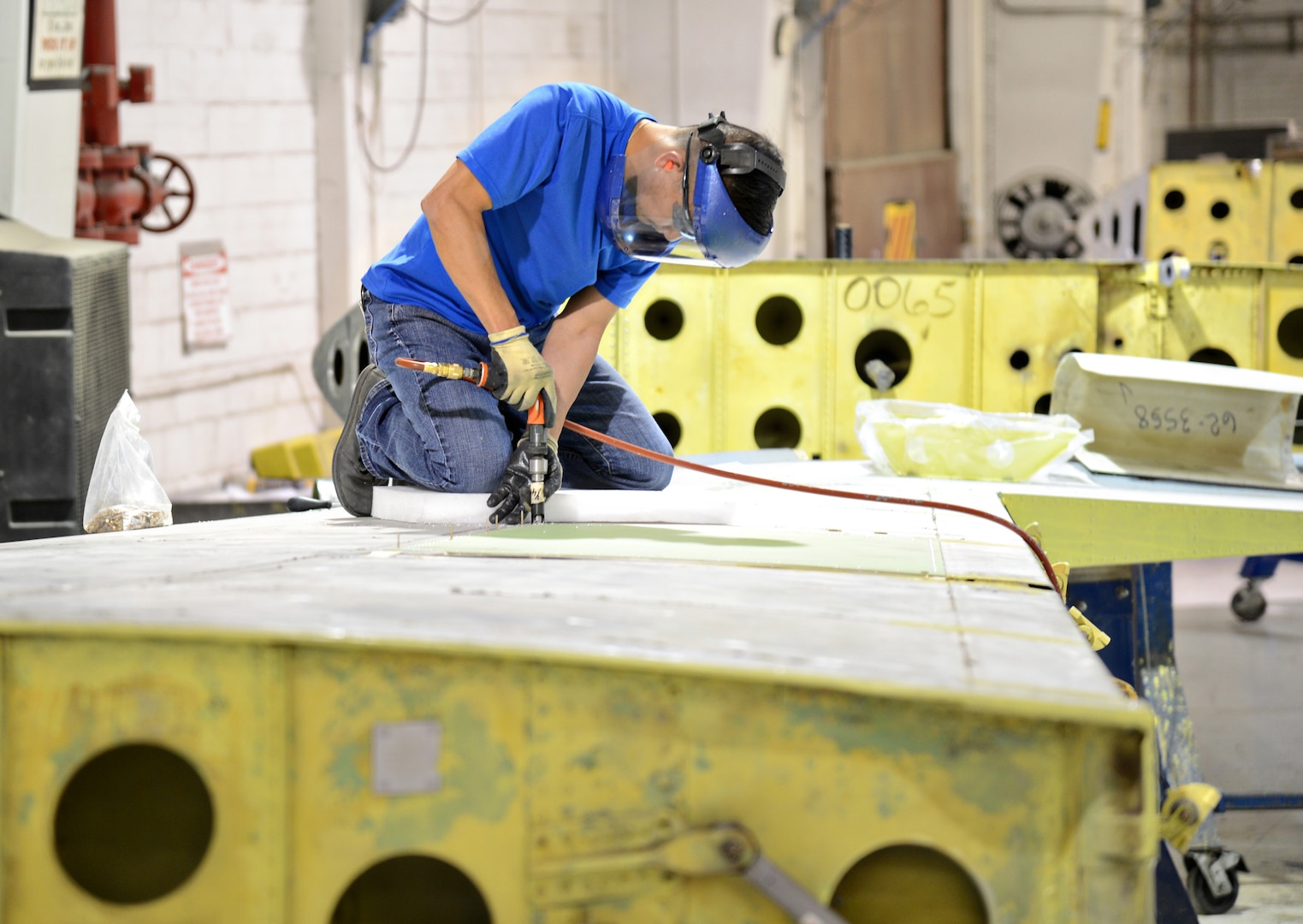 Danny Nguyen, a sheet metal mechanic with the 564th AMXS’ horizontal/vertical shop, repairs a panel for a KC-135 vertical stabilizer. (Air Force photo by Kelly White)