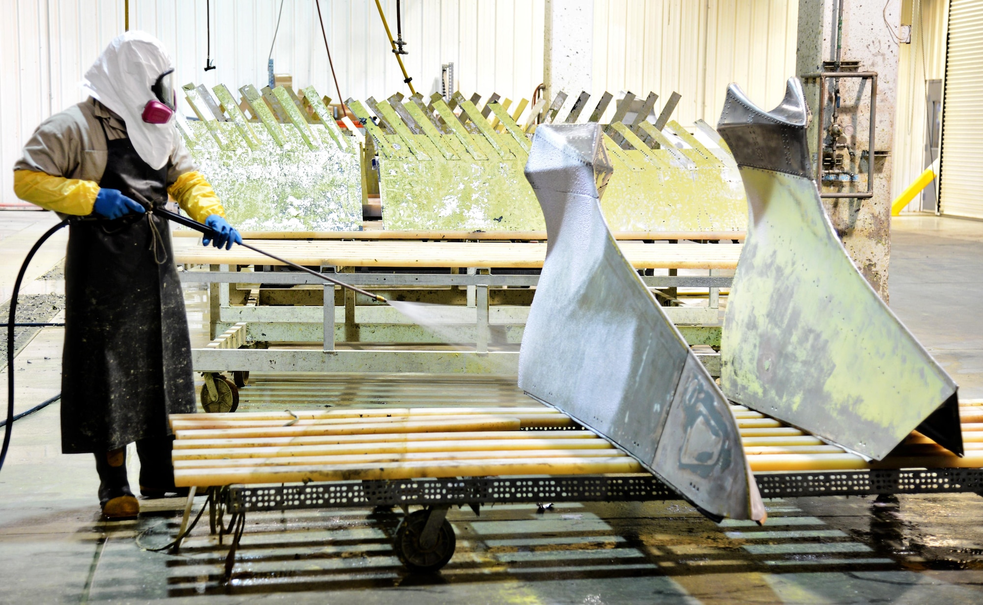 Kenny Mcewin, an equipment cleaner with the 564th AMXS, strips and de-masks “sailboats” and spoilers for a B-52 using 50/50 to take off the paint and primer. (Air Force photo by Kelly White)