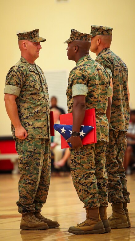 Col. Peter D. Buck (left) receives awards from Maj. Gen. Matthew G. Glavy (right) and Sgt. Maj. Derrick M. Mays (center) during a change of command ceremony aboard Marine Corps Air Station Beaufort, July 7. Colonel Peter Buck relinquished command of the Air Station to Col. Timothy P. Miller, who most recently served at U.S. Pacific Command as the Warfighting Exercises Branch Chief. Buck, who assumed command on Feb. 13, 2014, is retiring from the Marine Corps after 30 years of dedicated service.