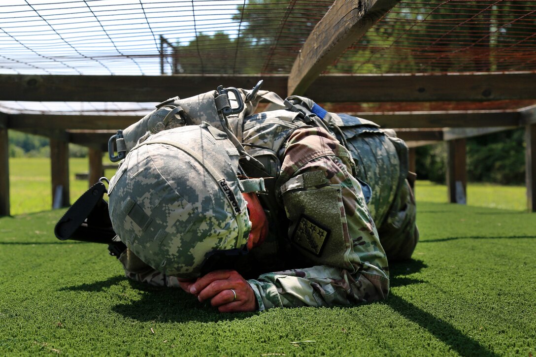 Army Pfc. Jessellie Boeker low crawls under a wire obstacle during the Best Warrior Competition’s obstacle course portion of the stress shoot at Aberdeen Proving Ground, Md., July 10, 2017. Boeker is assigned to the 20th Chemical, Biological, Radiological, Nuclear and Explosives Command. Army photo by Sgt. Kalie Jones