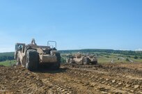 Spc. Nathan Plank, 926th  Engineer Brigade, operates his scraper in formation with a fellow engineer to move 100,000 cubic meters of dirt from a hill top during Resolute Castle 17, in Cincu Romania, July 14, 2017.  Resolute Castle 2017 is a U.S. Army Reserve led, United States Army Europe sponsored, Multi-Component, Multi-National Engineer Readiness Training Exercise.   Resolute Castle improves interoperability, enhances confidence and security assurance between partner nations, and improve infrastructure, capability and capacity at select locations.