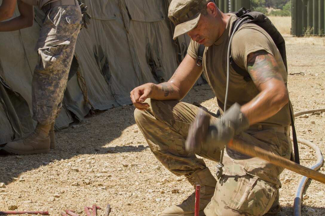U.S. Army Reserve Sgt. Seth Kelley drives in a tent stake during the set up phase of the 91st Training Division's Combat Support Training Exercise (CSTX) on July 12, 2017. Kelley and other soldiers were trained on various tasks and drills to maintain mission readiness through out the CSTX. (U.S. Army photo by Spc. Derek Cummings/Released)