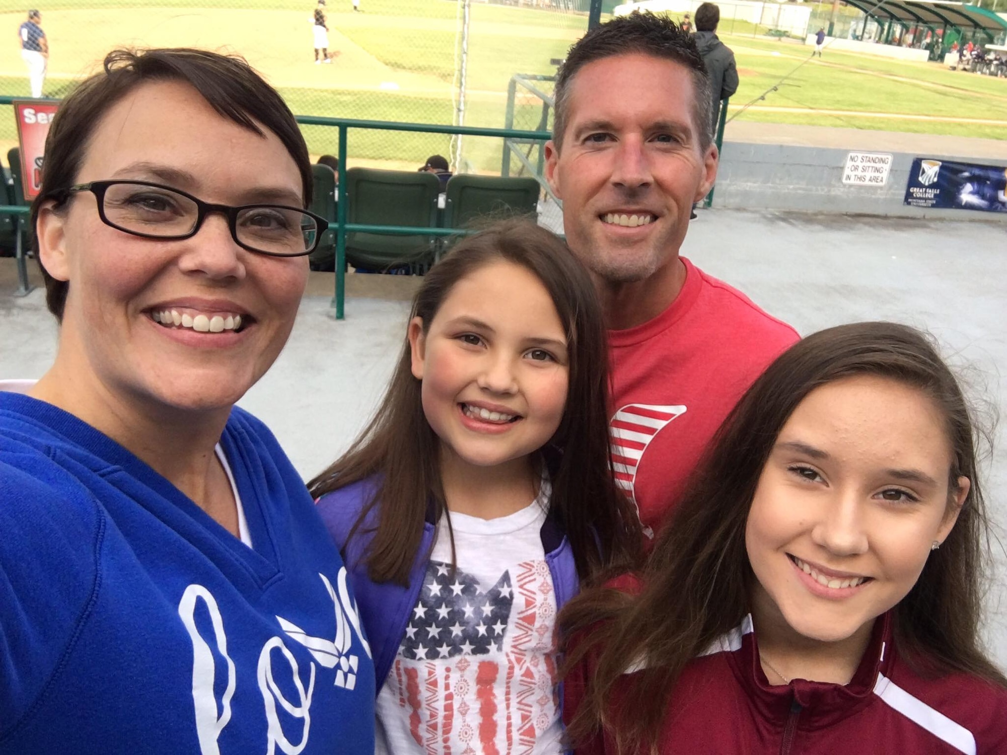 Chief Master Sgt. Amber Mitchell, 341st Missile Wing command chief, her daughters Marin, left, and Taylor, and her husband Brian, take a photo during a baseball game June 22, 2017, at Great Falls, Mont. Mitchell has taken the reigns as the new command chief here and is excited to bring her experiences, personality and goals to all of Team Malmstrom. (Courtesy photo)