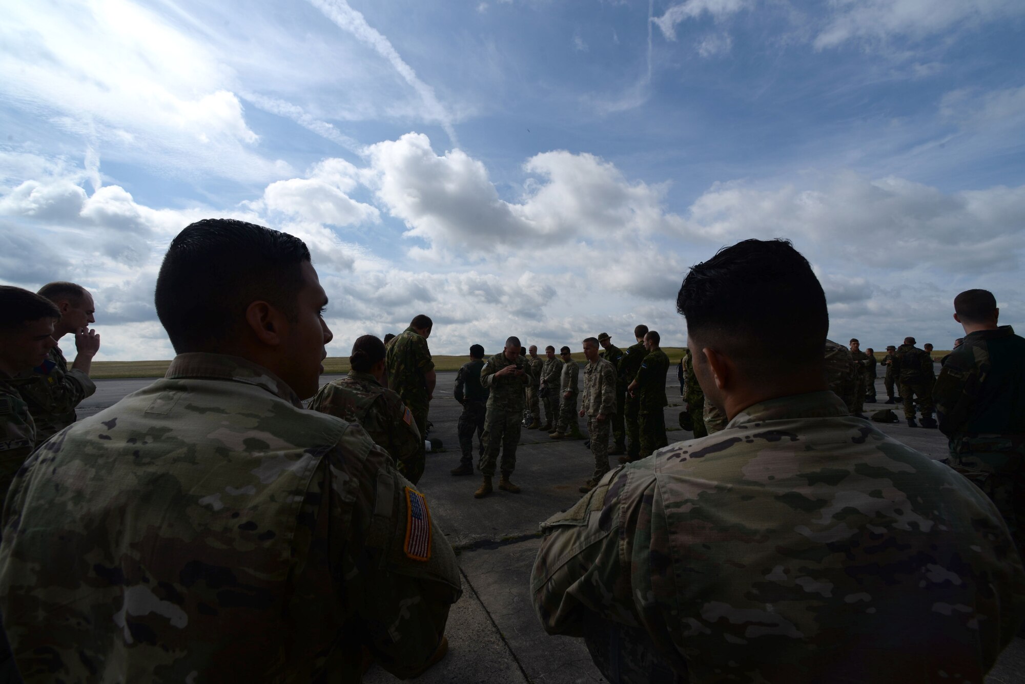 Service members gather around for accountability during International Jump Week in Bitburg, Germany, July 11, 2017. More than 500 service members were dropped over the five day training and organizers were able to close out the week without any major injuries. (U.S. Air Force photo by Airman 1st Class D. Blake Browning)