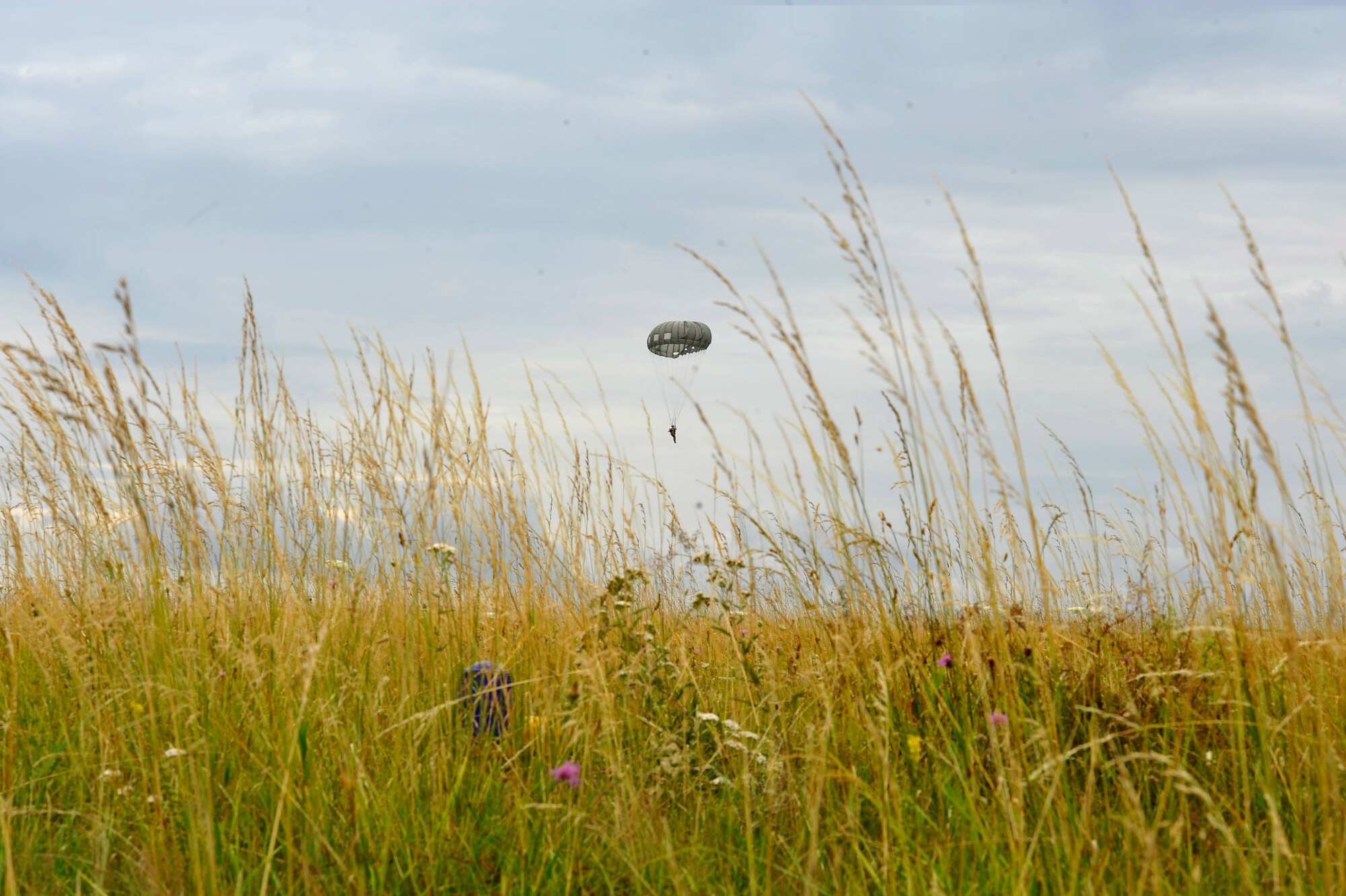 A parachutist prepares for landing at International Jump Week in Bitburg, Germany, July 11, 2017. The training performed during this exercise standardizes parachuting between partner nations. (U.S. Air Force photo by Airman 1st Class D. Blake Browning)