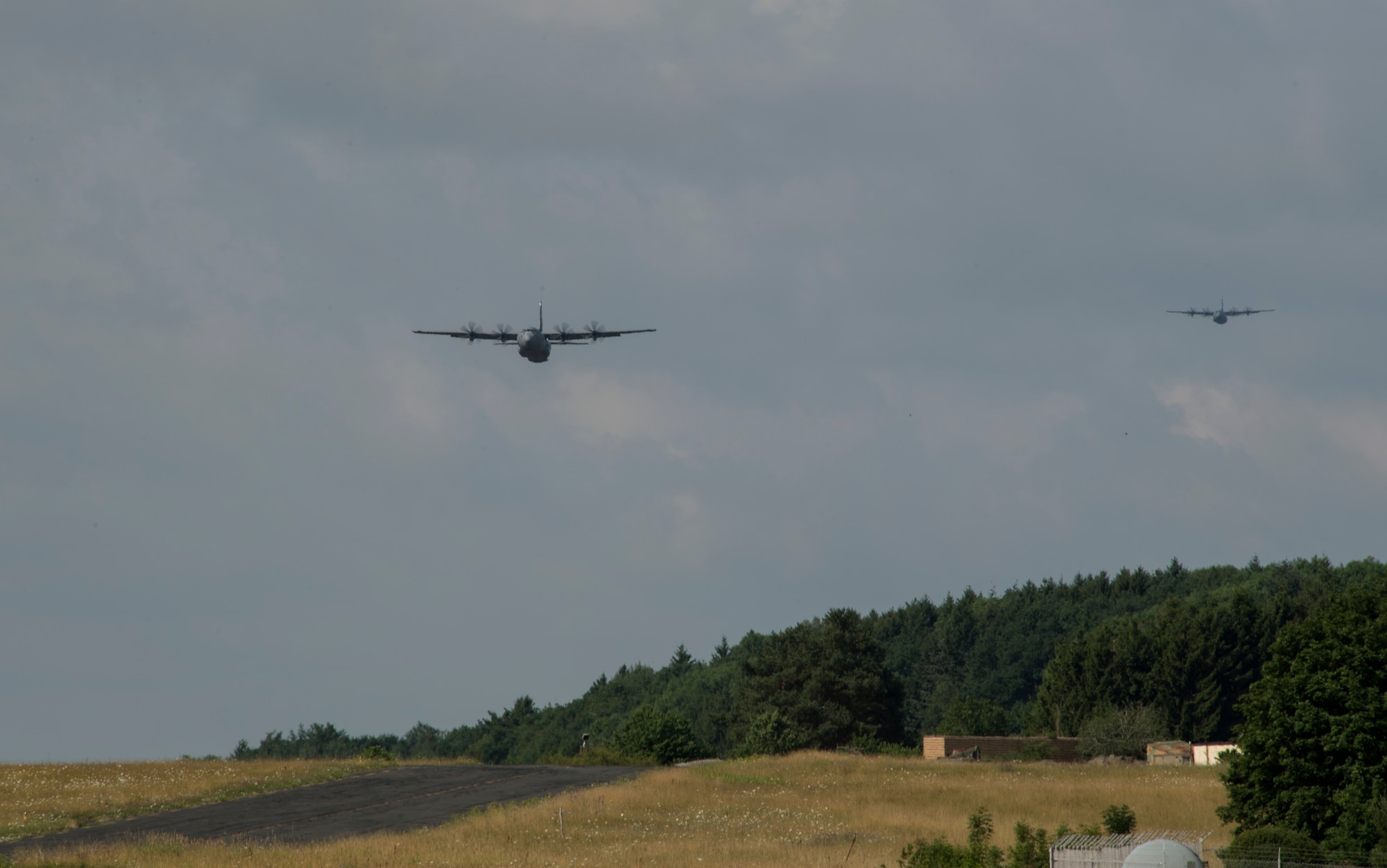 Two U.S. Air Force C-130J Super Hercules fly in formation during International Jump Week at Bitburg, Germany, July 11, 2017. Approximately 500 service members from more than 13 partner nations participated in this year’s training. (U.S. Air Force photo by Senior Airman Tryphena Mayhugh)