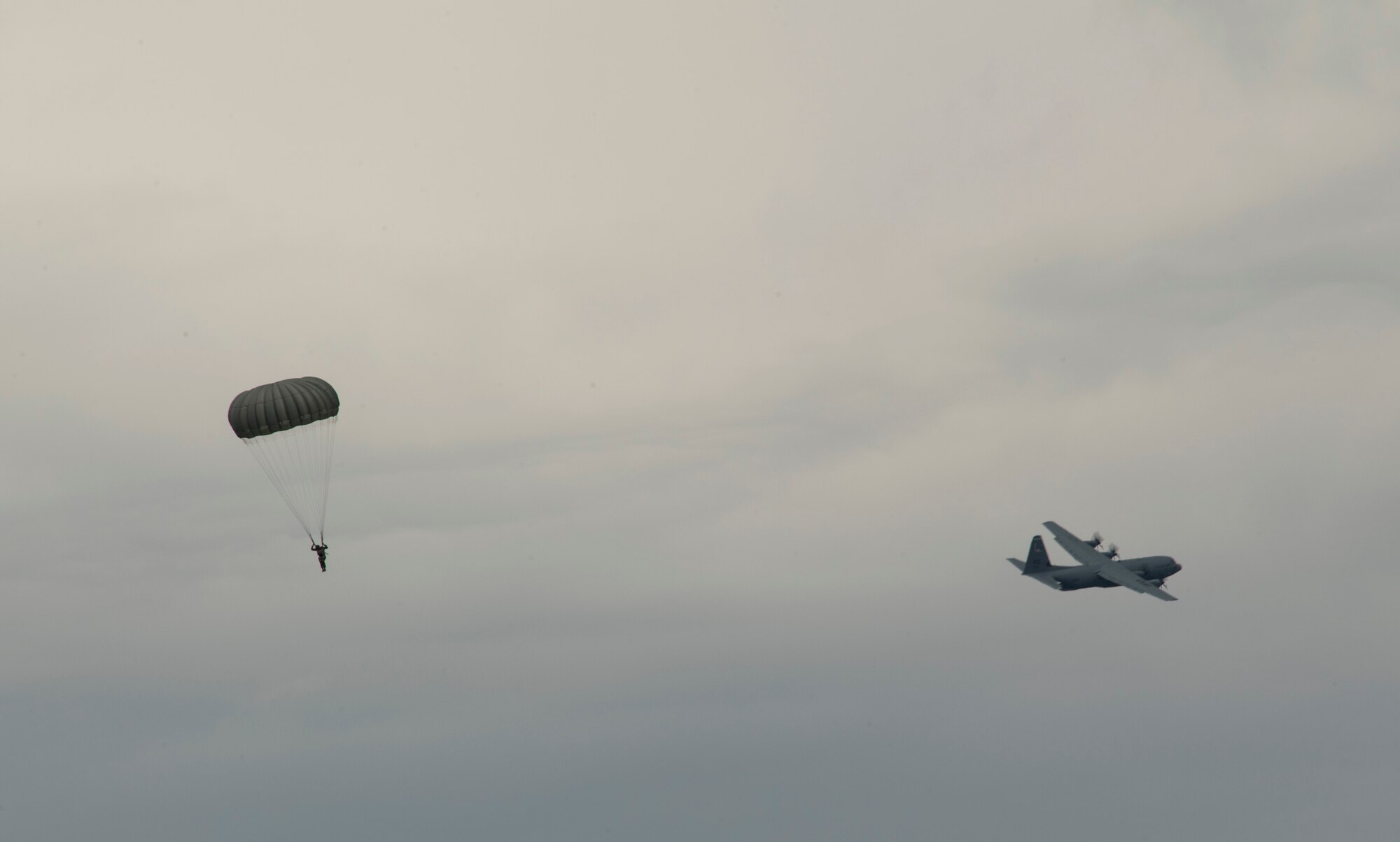 A paratrooper descends to the ground after jumping from a U.S. Air Force C-130J Super Hercules during International Jump Week at Bitburg, Germany, July 11, 2017. More than 500 service members were dropped over the five day training and organizers were able to close out the week without any major injuries. (U.S. Air Force photo by Senior Airman Tryphena Mayhugh)