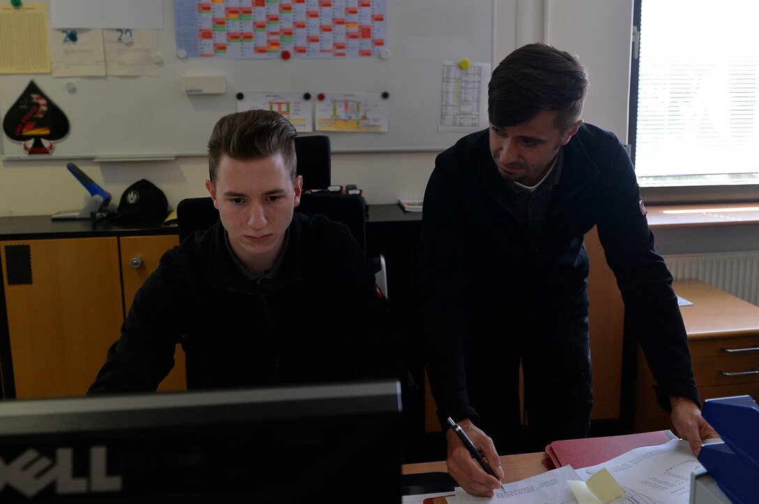 Andreas Lorenz, 435th Construction and Training Squadron supervisory purchasing agent (right), coaches his apprentice, Felix Myer, 435th CTS administrative service clerk, on computer operations on Ramstein Air Base, Germany Jul. 13, 2017. The 435th CTS’s three-year apprenticeship program provides vocational training opportunities for local national youth. (U.S. Air Force photo by Airman 1st Class Joshua Magbanua)