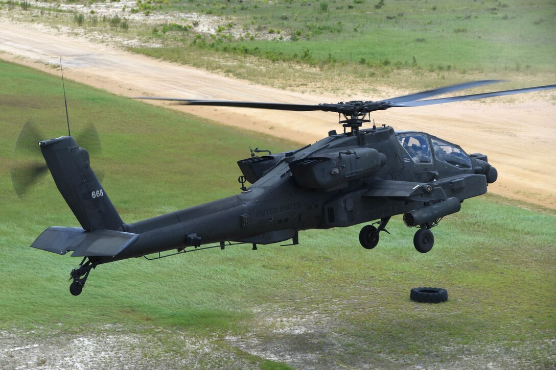 South Carolina Army National Guard pilots hover an AH-64 Apache helicopter before firing a 30 mm automatic chain gun while qualifying on daytime aerial gunnery range operations at Fort Stewart, Ga., July 9, 2017. Army National Guard photo by Capt. Jessica Donnelly
