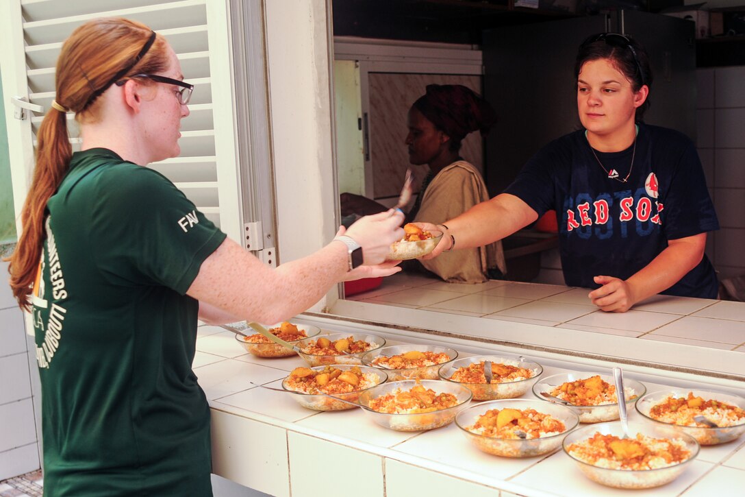 Army Spc. Nicole Powell and Army Spc. Chelsea Williams help prepare lunch at the Caritas refugee compound in Djibouti, July 6, 2017. The soldiers are assigned to Headquarters and Headquarters Company, 1st Battalion, 153rd Infantry Regiment, 39th Infantry Brigade Combat Team. Army National Guard photo by Spc. Victoria Eckert