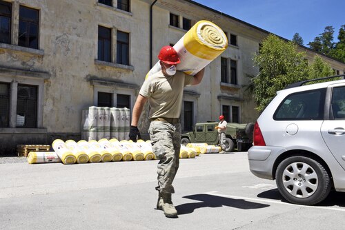 Senior Airman Garth Mitchell, 219th RED HORSE Squadron structures journeyman, carries a roll of insulation to the attic of a barracks June, 9, 2017, at Pocek base, near Postonja, Slovenia. RED HORSE was tasked to insulate, create a catwalk and add lighting to a barracks attic as a part of Exercise Related Construction. (U.S. Air National Guard photo/Staff Sgt. Lindsey Soulsby)
