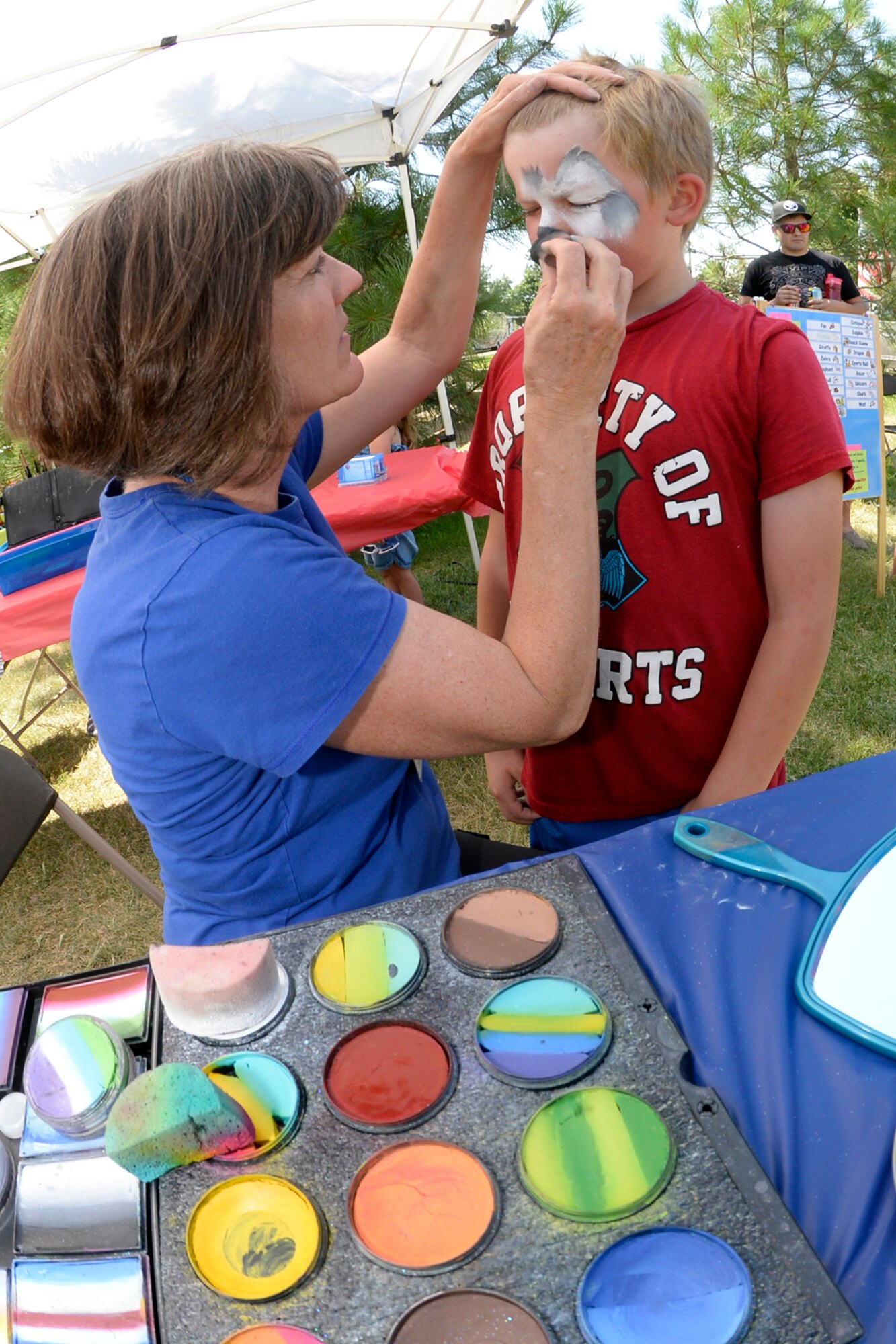 Susan Osler with Changing Faces, a local community sponsor, gives Calvin Lyons a new and fun face during the annual Salute Picnic, July 14 at Centennial Park. The event pulled dozens of community sponsors together to provide a day of food and fun for military members and families, and showed appreciation to those who serve. (Air Force photo/Todd Cromar)