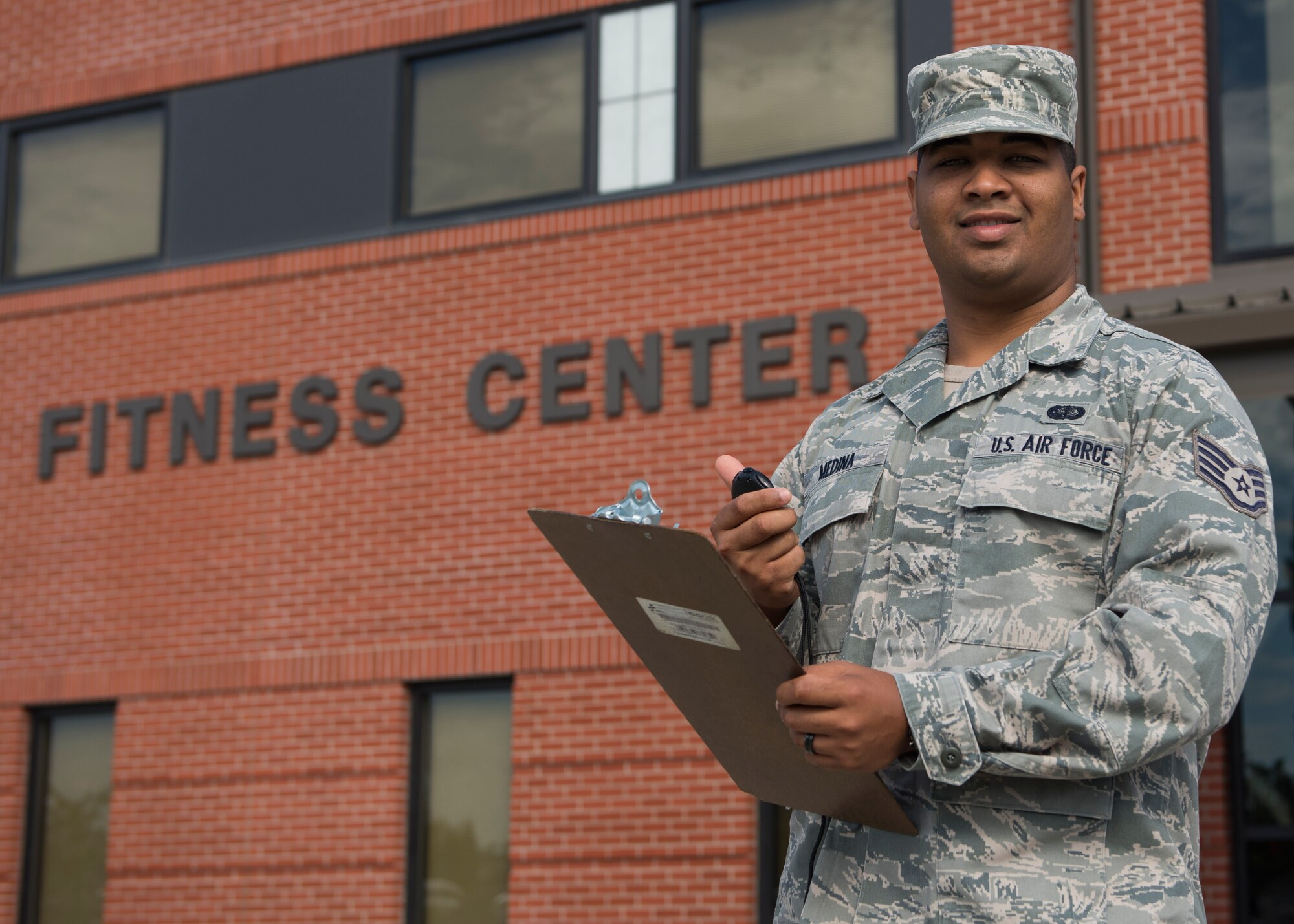 SSgt. Miguel Medina, 92nd Force Support Squadron fitness journeyman, poses in front of the base Fitness Center July 7, 2017, at Fairchild Air Force Base, Washington. Medina is the supervisor of the Physical Fitness Testing program for the base. (U.S. Air Force photo / Airman 1st Class Ryan Lackey)