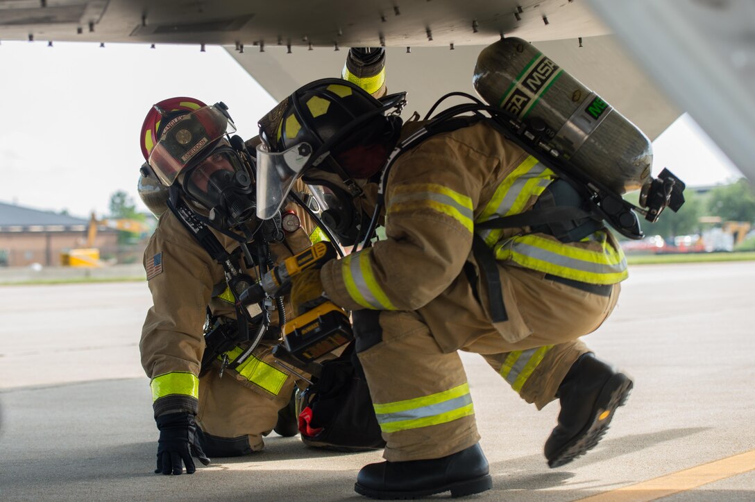 (From left) James Sneeden, 633rd Civil Engineer Squadron fire department lead crew chief, and U.S. Air Force Senior Airman James Bomber, 633rd CES fire department driver-operator, inspect a simulated downed aircraft during an exercise at Joint Base Langley-Eustis, Va., July 11, 2017. The exercise tested the fire department’s capability to safely and accurately inspect a downed aircraft for potential hazards before removing a simulated injured pilot. (U.S. Air Force photo/Senior Airman Derek Seifert)