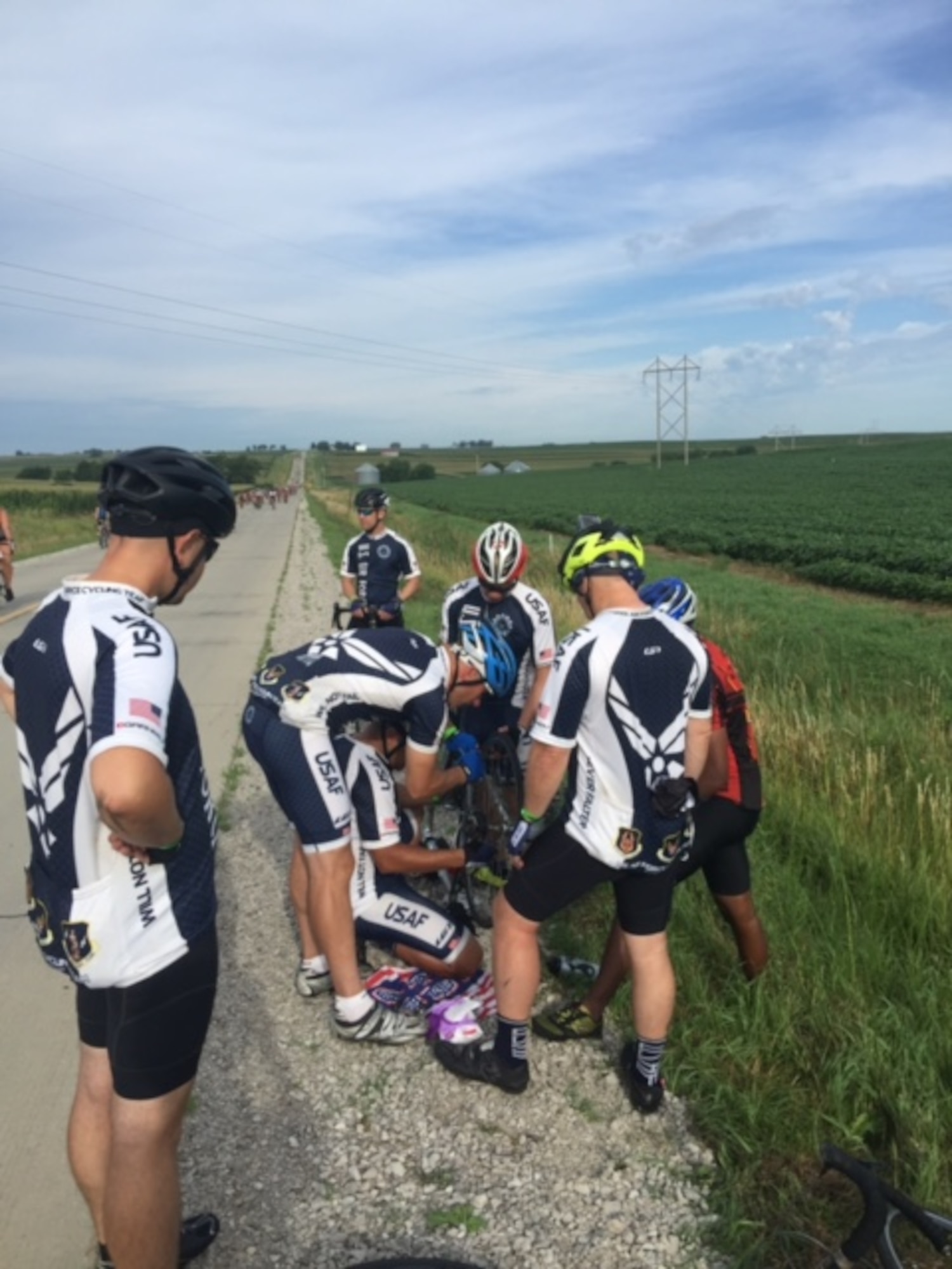 Members of the Air Force cycling team assist a cycler whos bike tire went flat at RAGBRAI 2016. The team members are known as "guardian angels" on the 500-mile bike ride because they stop to help every person they find in distress along the route. 