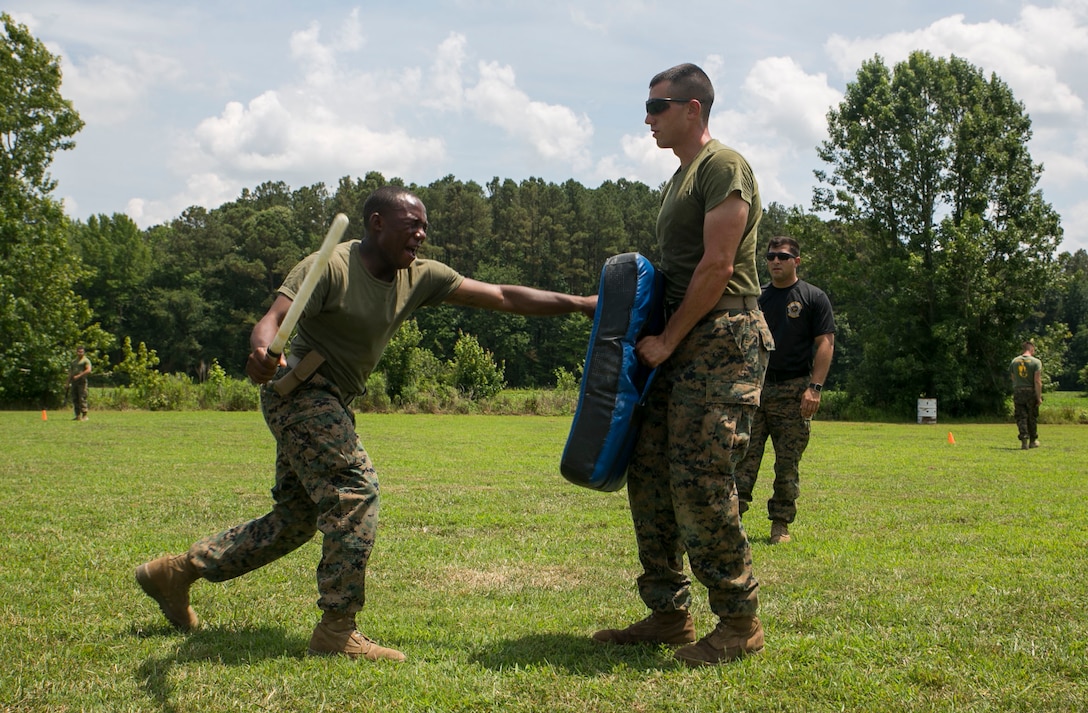 A student of the Basic Security Guard Course, Training Co., Marine Corps Security Force Regiment, executes baton strikes after being sprayed across the face with oleoresin capsicum spray during a non-lethal training exercise at the BSG course aboard Naval Support Activity Northwest Annex, Chesapeake, Va., July 13. BSG is a six-week course in which Marines spend time learning non-lethal techniques, various weapon systems, and interior guard. (Official U.S. Marine Corps photo by Cpl. Logan Snyder/ Released)