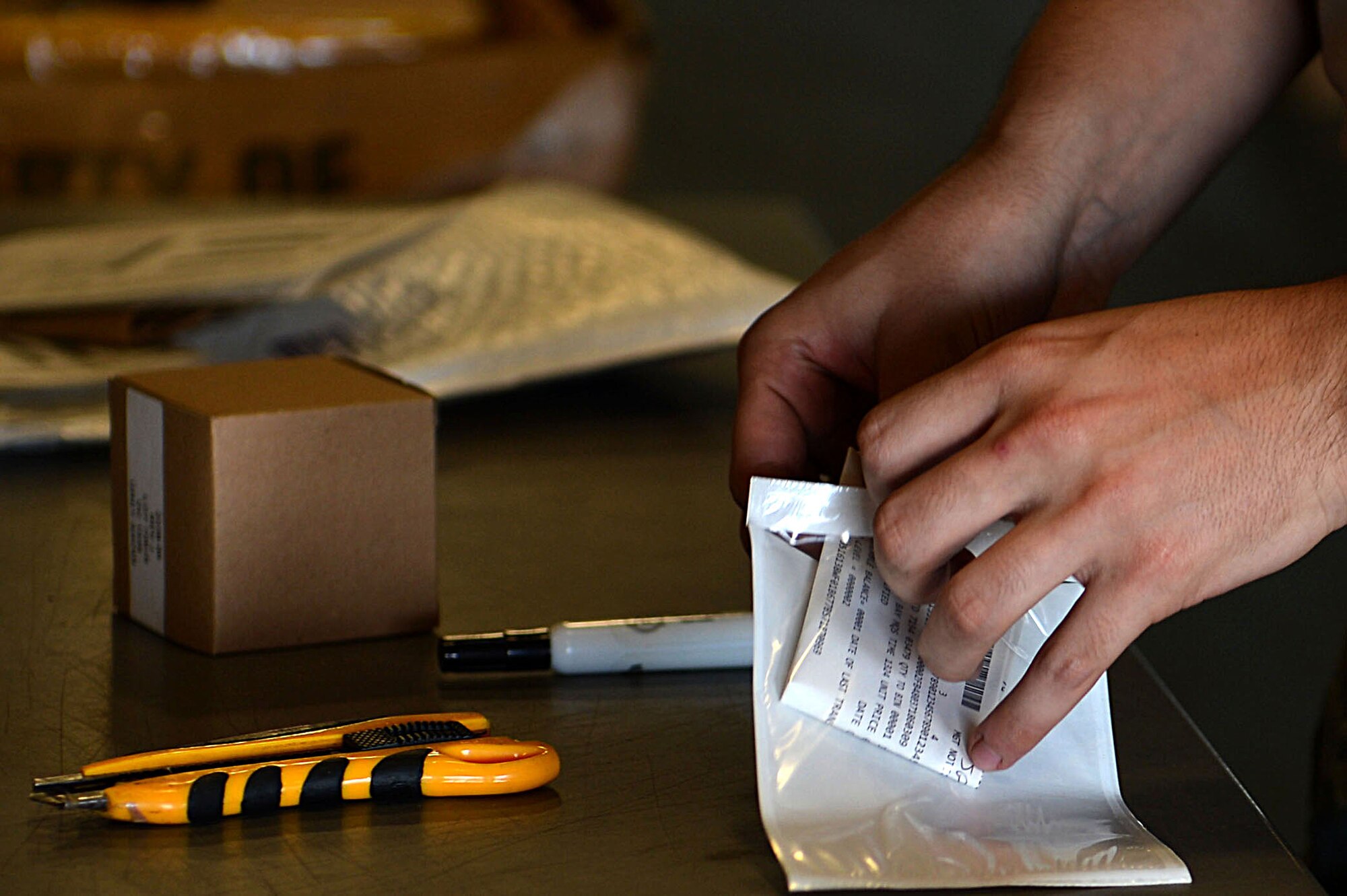 U.S. Air Force Senior Airman Tyler Peterson, 20th Logistics Readiness Squadron (LRS) inbound cargo technician, inserts a label into a sleeve at the 20th LRS cargo facility at Shaw Air Force Base, S.C., July 13, 2017. Airmen assigned to the 20th LRS inbound and outbound cargo flights ensure that mission-related gear shipped to and from the base is properly packed, labeled and ready for delivery. (U.S. Air Force photo by Senior Airman Christopher Maldonado)