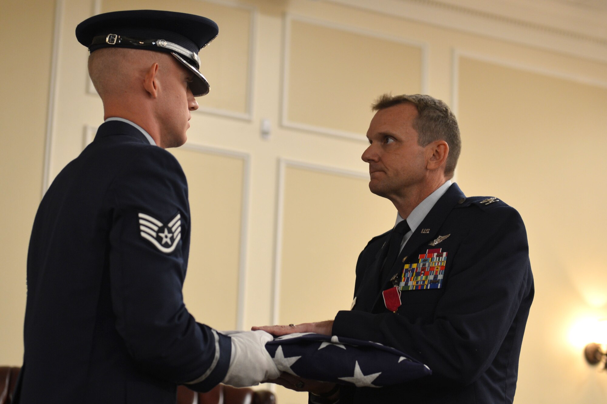 U.S. Air Force Col. Dustin P. Smith,right, Headquarters U.S. Air Forces Central Command chief of staff, receives a flag from the Team Shaw Honor Guard during his retirement ceremony, July 14, 2017, Shaw Air Force Base, S.C. Smith was a senior air battle manager with 1,800 flight hours in the NATO E-3A and E-3 B/C aircraft. (U.S. Air Force photo by Senior Airman Christopher Maldonado)