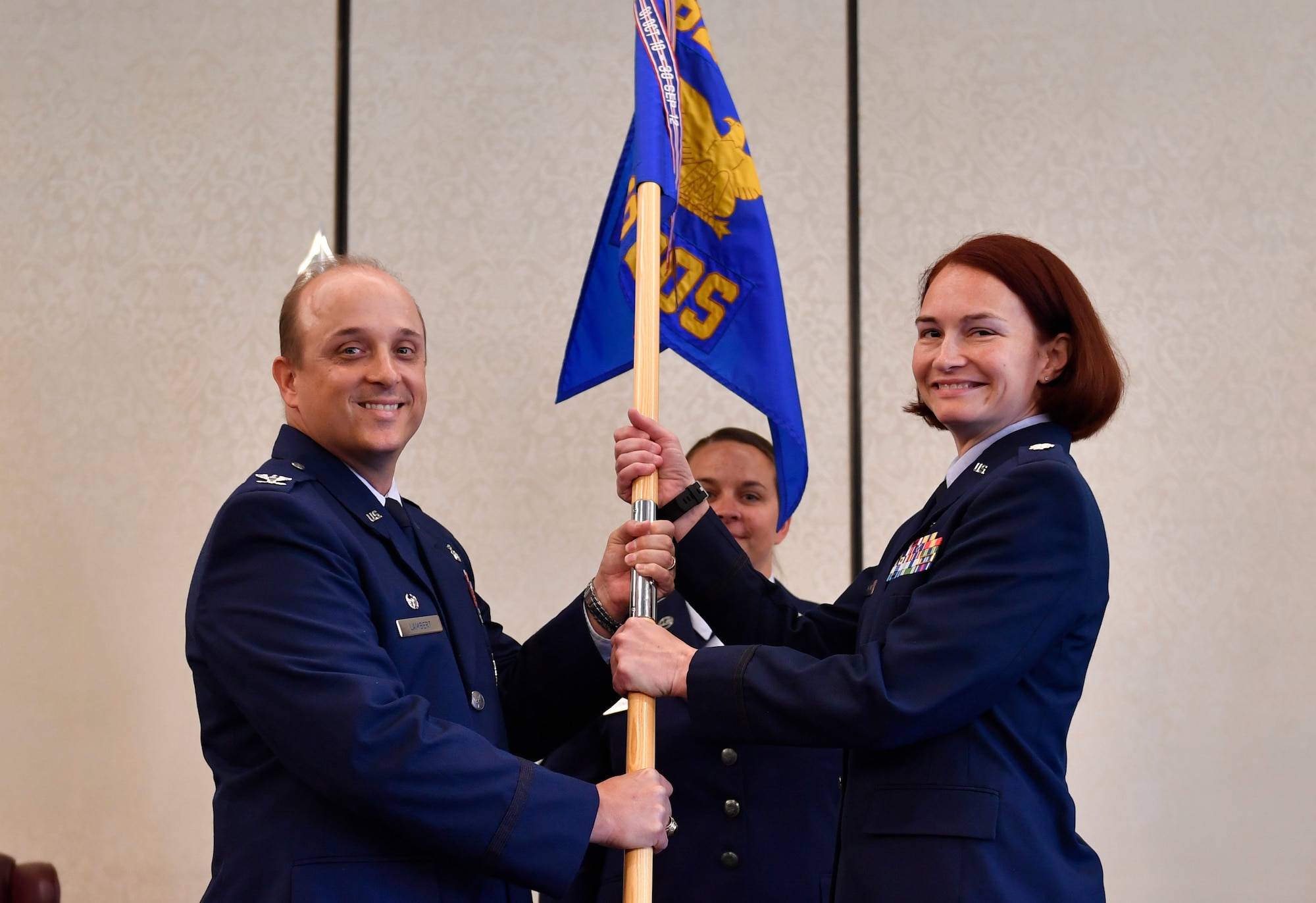 Col. Randall Lambert, left, 628th Medical Group commander, passes the guidon to Lt. Col. Christine Smetana, right, 628th Medical Operations Squadron incoming commander, during the 628th MDOS change of command ceremony at Joint Base Charleston, S.C., July 14, 2017. The squadron bid farewell to the outgoing commander Lt. Col. Brian Neese and welcomed Smetana as the new squadron commander. 