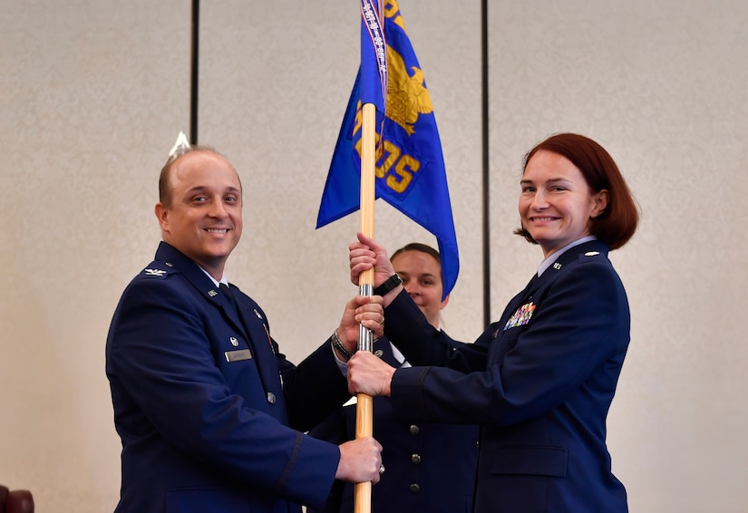 Col. Randall Lambert, left, 628th Medical Group commander, passes the guidon to Lt. Col. Christine Smetana, right, 628th Medical Operations Squadron incoming commander, during the 628th MDOS change of command ceremony at Joint Base Charleston, S.C., July 14, 2017. The squadron bid farewell to the outgoing commander Lt. Col. Brian Neese and welcomed Smetana as the new squadron commander. 
