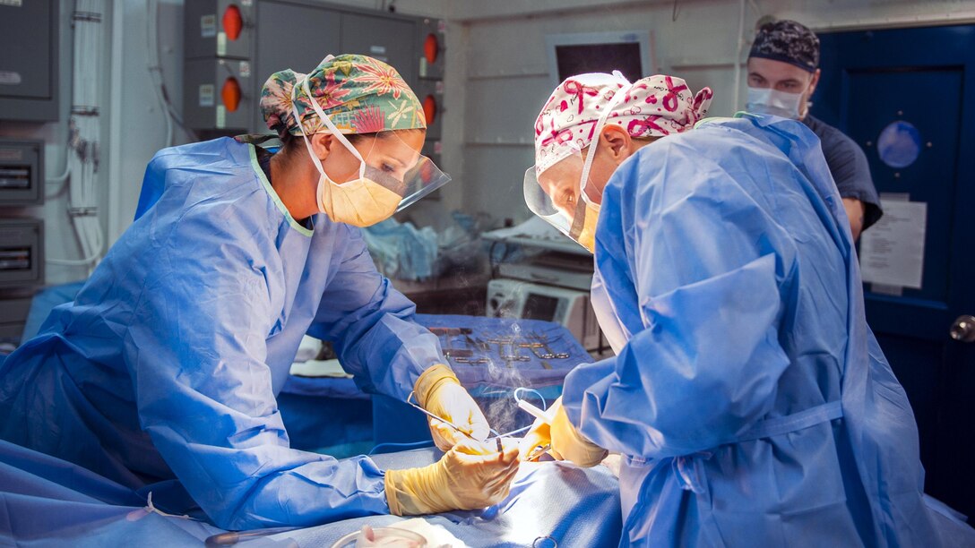 Navy Hospital Corpsman 1st Class Christina Sizemore, left, and Lt. Cmdr. Krista Puttler, a ship’s surgeon, perform surgery aboard the aircraft carrier USS George H.W. Bush in the Mediterranean Sea, July 11, 2017. The ship and its carrier strike group are conducting naval operations in the U.S. 6th Fleet area of operations to support U.S. national security interests in Europe and Africa. Navy photo by Petty Officer 3rd Class Joe Boggio