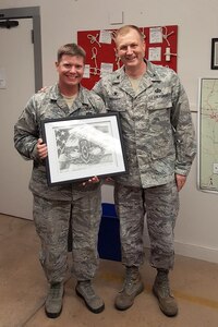 Col. Jonathan Wright, 502nd Installation Support Group commander, presents Tech. Sgt. Daniel Solon, 502nd Civil Engineer Squadron explosive ordnance disposal technician, a drawing of the EOD badge in appreciation for an outstanding mission briefing Solon delivered, Sept. 21 at Joint Base San Antonio-Lackland, Texas.