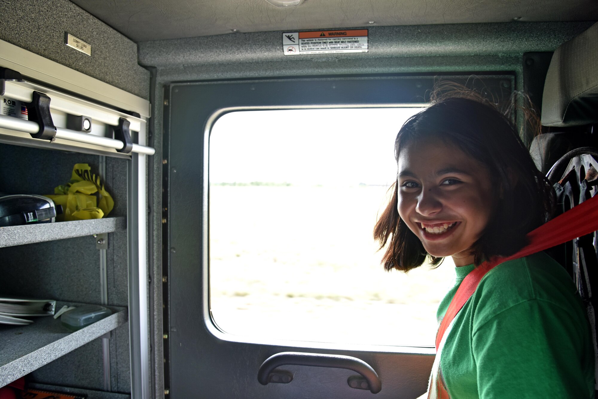 Alexa Fadilla, junior firefighter, rides in a firetruck during the junior firefighter camp at the fire station on Goodfellow Air Force Base, Texas, July 13, 2017. The firefighters taught the children a variety of skills during the camp including the importance of staying low during a fire and first aid tips. (U.S. Air Force photo by Staff Sgt. Joshua Edwards/Released)