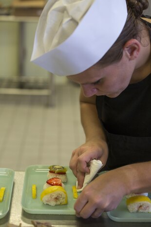 U.S. Marine Corps Sgt. Kelly Bushey, the food service operations chief with Headquarters and Headquarters Squadron (H&HS), wipes a plate for proper presentation during the Food Service Specialist of the Quarter competition at Marine Corps Air Station Iwakuni, Japan, July 13, 2017. The event prepared Marines for a larger competition July 26-27 in Okinawa. Bushey was the sous to U.S. Marine Corps Sgt. Ayesha L. Zantt, a food service specialist with H&HS. Together they made a fruit rendition of sushi to incorporate Japanese culture in their dessert. (U.S. Marine Corps photo by Lance Cpl. Gabriela Garcia-Herrera)