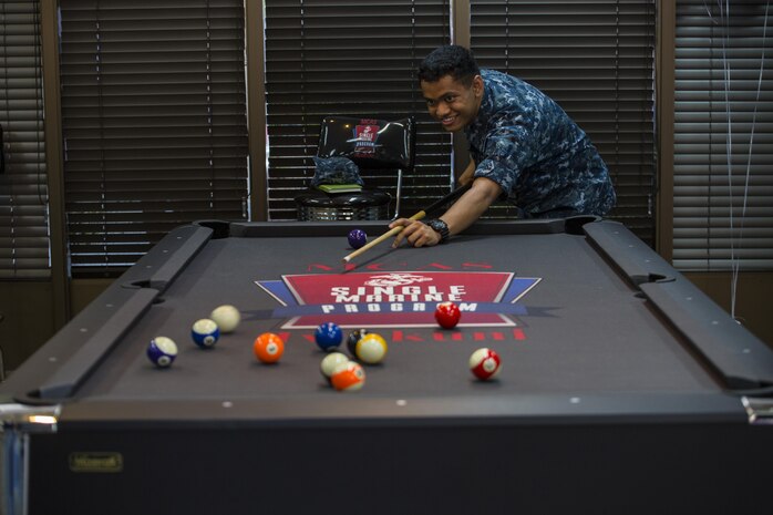 U.S. Navy Seaman Miguel Prima, a preventative medicine technician at the Robert M. Casey Medical and Dental Clinic, plays pool at the Single Marine Program’s Marine Lounge grand opening at Marine Corps Air Station Iwakuni, Japan, July 14, 2017. Originally located on the second floor over Crossroads Mall, the Marine Lounge was moved to make it more available to single and unaccompanied service members on the air station. The lounge provides tablets for service members to check out. The new movie room offers a better experience because of new recliners, an 86-inch television and a brand new surround sound speaker system. (U.S. Marine Corps photo by Lance Cpl. Gabriela Garcia-Herrera)