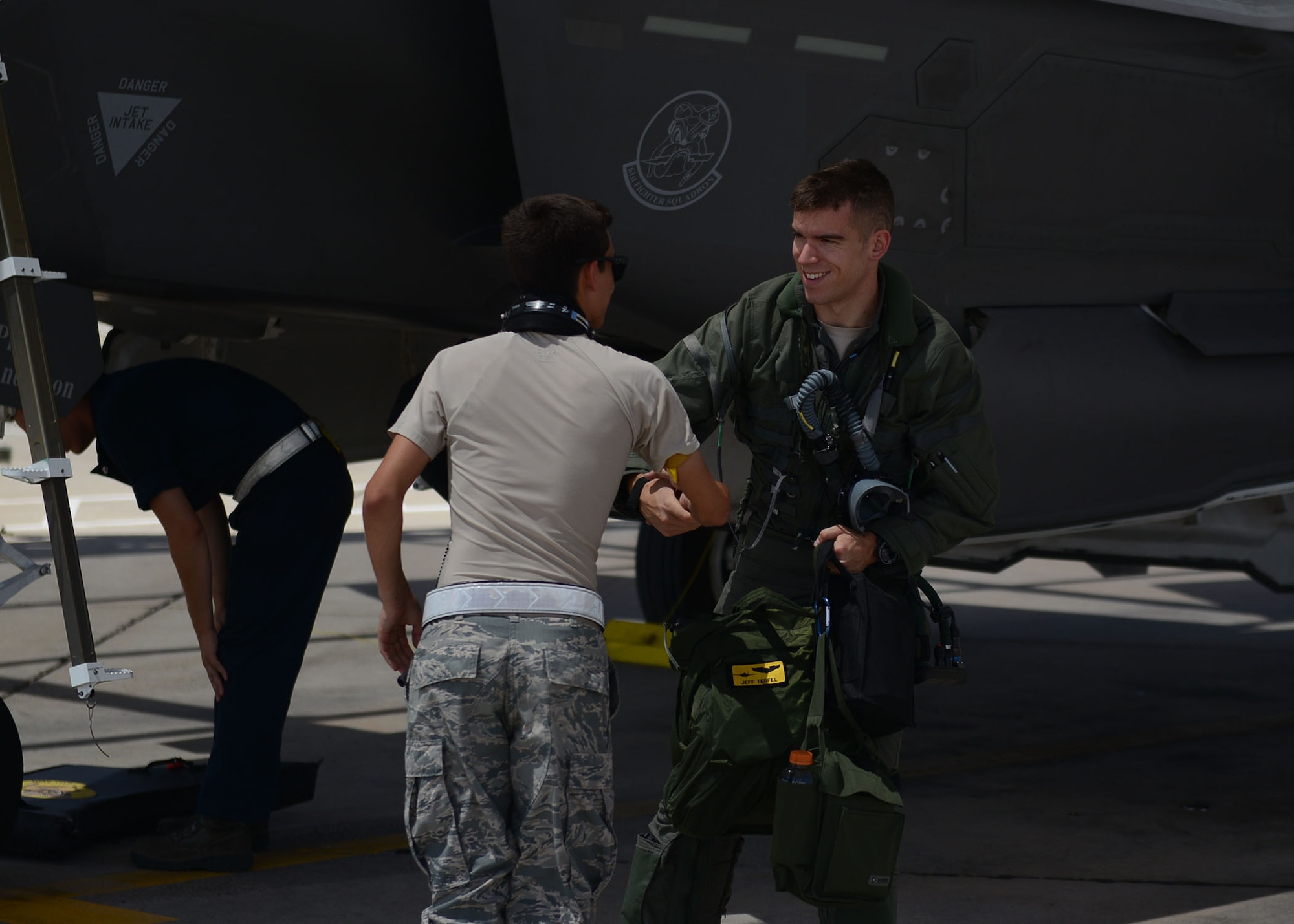 1st Lt. Jeff Teufel, 61st Fighter Squadron basic course student, shakes hands with his crew chief after landing from his capstone flight at Luke Air Force Base, Ariz., July 17, 2017. Teufel was taking off for his capstone flight where he faced off against 309th Fighter Squadron F-16 Fighting Falcons. (U.S. Air Force photo/Senior Airman James Hensley)