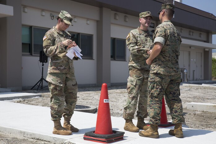 U.S. Army Lt. Col. Dwayne Bechtol, Public Health Activity Japan commanding officer, center, shakes hands with U.S. Marine Corps Lt. Col. Gary Thomason, the Marine Corps Air Station (MCAS) Iwakuni executive officer, during the opening of the veterinary clinic at MCAS Iwakuni, July 13, 2017. The new facility was built to accommodate the growing number of patients and military working dogs on the air station. The veterinary clinic is responsible for the welfare of hundreds of military pets and military working dogs. The new facility allows technicians to double the amount of patients they can see. (U.S. Marine Corps photo by Sgt. N.W. Huertas)