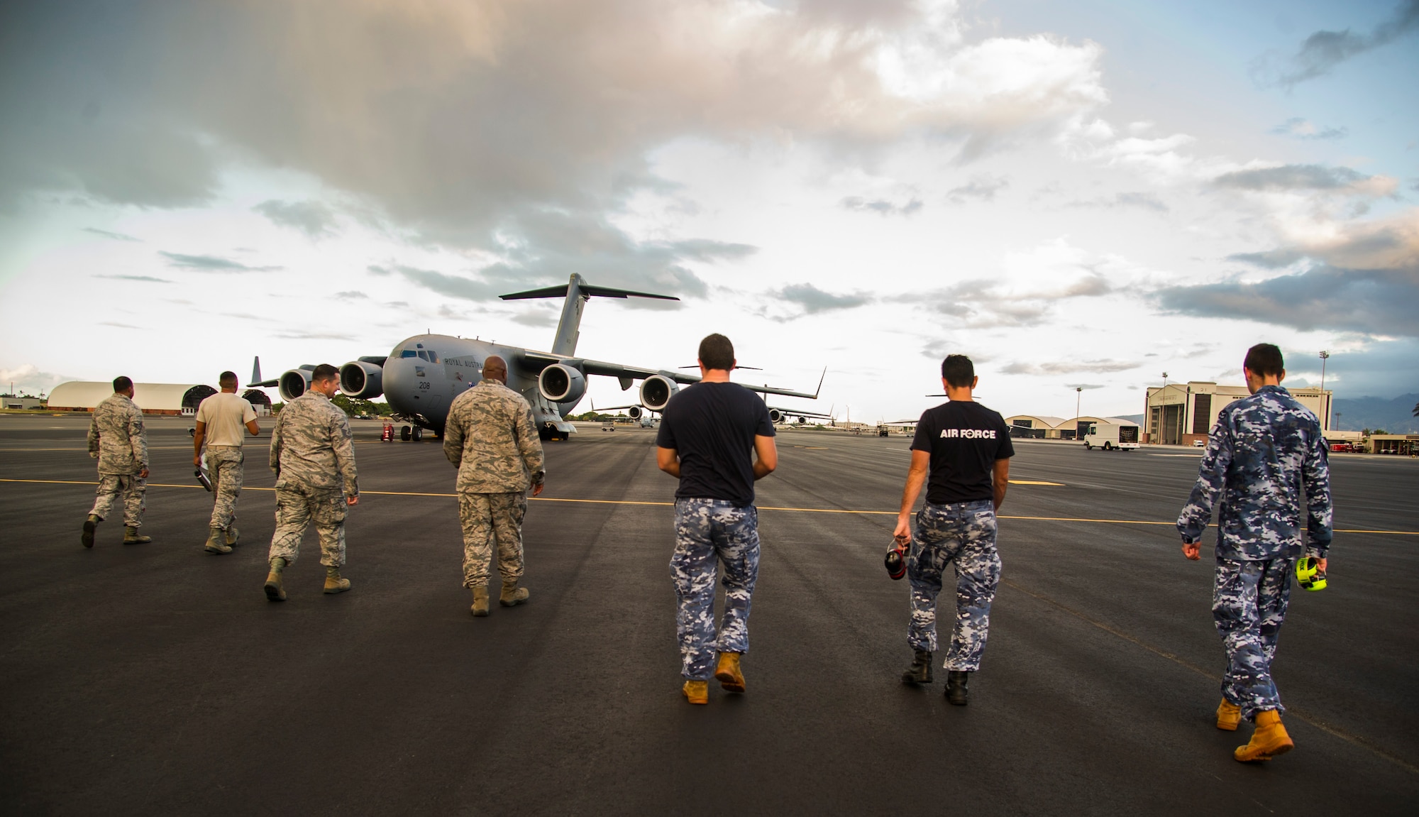 Maintainers from the 15th Maintenance Group and members from the 36th Squadron from Royal Australian Air Force Base Amberley, search the flightline for debris on Joint Base Pearl Harbor-Hickam, Hawaii, July 12, 2017.  The Airmen came together for a week long combined Enhanced Air Cooperation training event designed to integrate maintenance capabilities between the U.S. and Australia.  (U.S. Air Force photo by Tech. Sgt. Heather Redman)