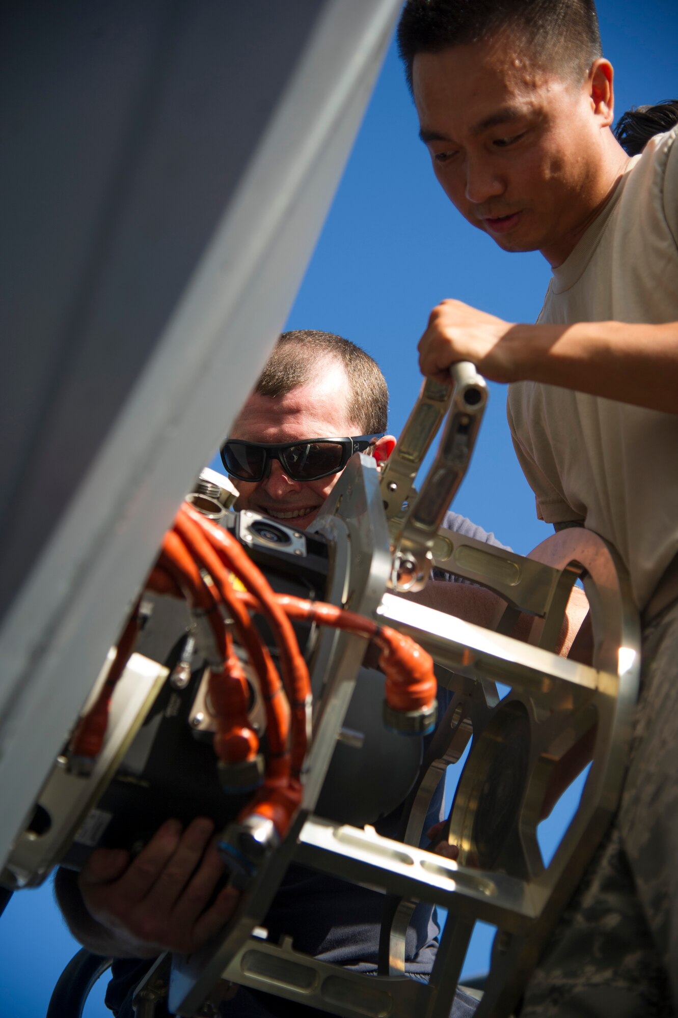 Royal Australian Air Force Leading Air Craftsman Todd Burton, 36th Squadron from Royal Australian Air Force Base Amberley, and U.S. Air Force Staff Sgt. Billy Chan, 154th Maintenance Squadron, remove a turret from a C-17 Globemaster III, on Joint Base Pearl Harbor-Hickam, Hawaii, July 12, 2017.  The Airmen came together for a week long combined Enhanced Air Cooperation training event designed to integrate maintenance capabilities between the U.S. and Australia.  (U.S. Air Force photo by Tech. Sgt. Heather Redman)  