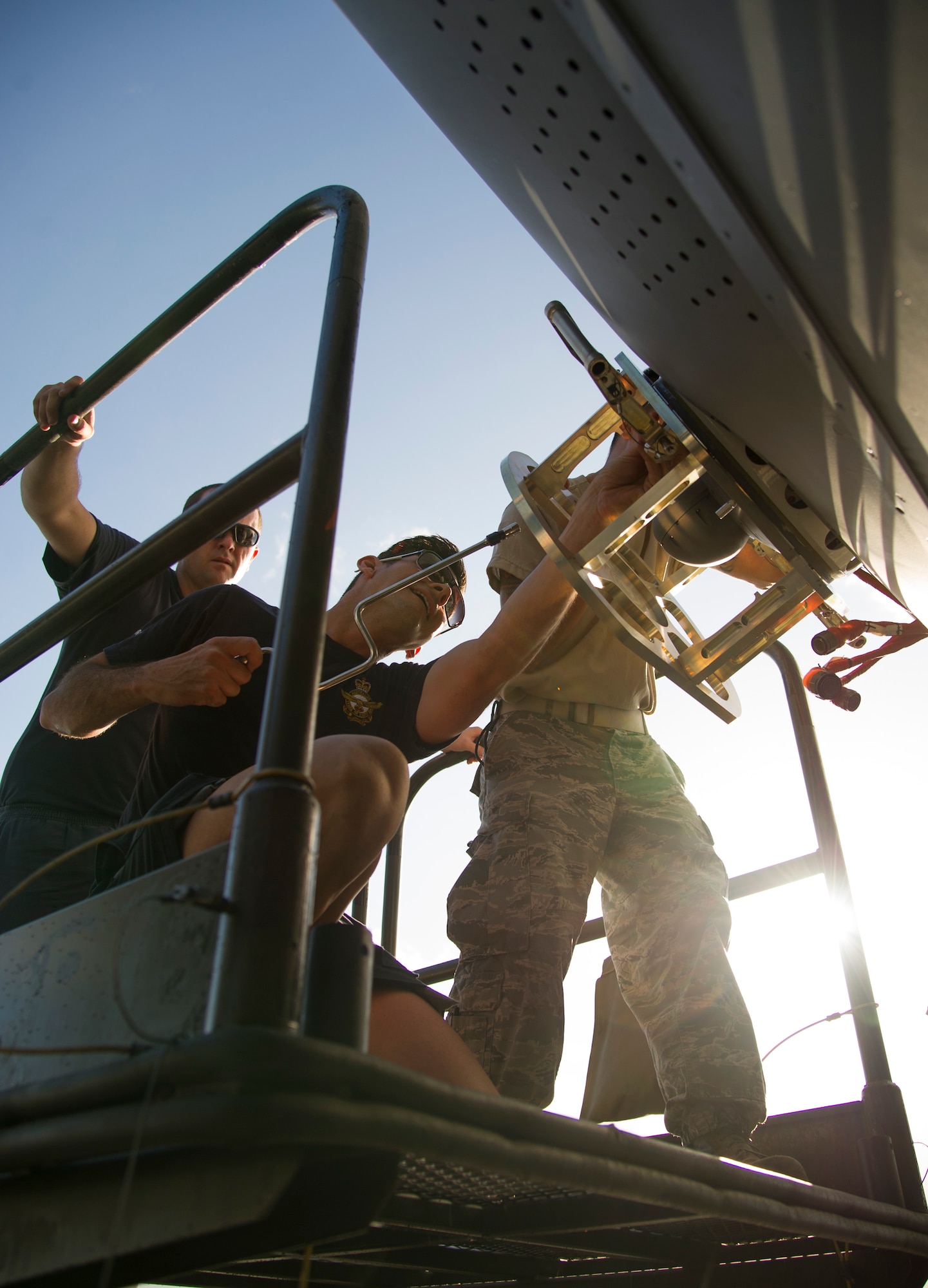 Royal Australian Air Force Leading Air Craftsman Todd Burton, and Sgt. Jared Parker, 36th Squadron from Royal Australian Air Force Base Amberley, and U.S. Air Force Staff Sgt. Billy Chan, 154th Maintenance Squadron, secure a turret from a C-17 Globemaster III, on Joint Base Pearl Harbor-Hickam, Hawaii, July 12, 2017.  The Airmen came together for a week long combined Enhanced Air Cooperation training event designed to integrate maintenance capabilities between the U.S. and Australia.  (U.S. Air Force photo by Tech. Sgt. Heather Redman)