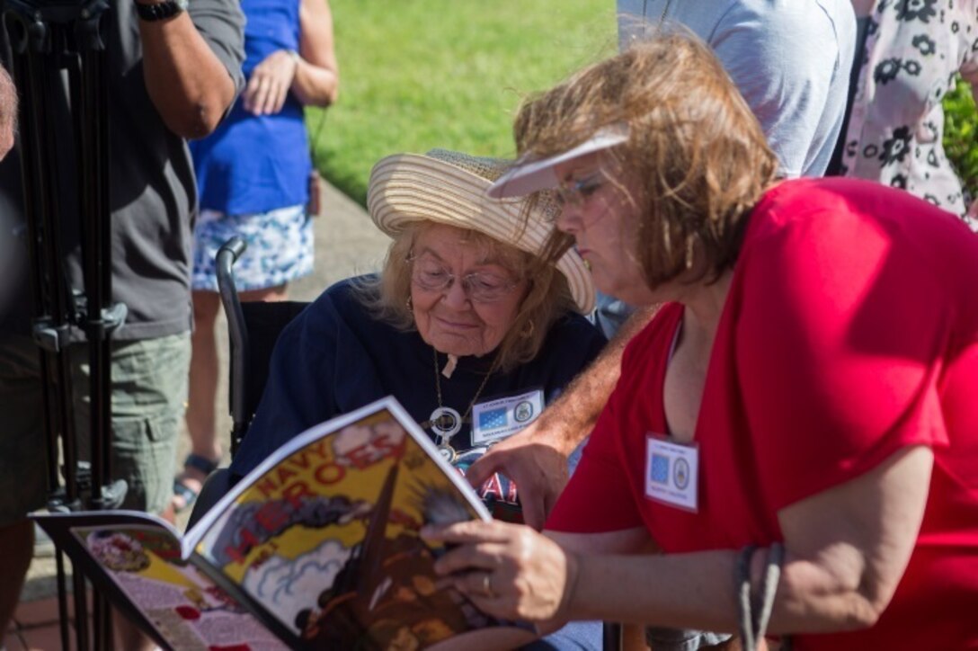 MARINE CORPS BASE HAWAII - Members of John Finn’s family pick out his name in a copy of “Navy Heroes” during a tour aboard Marine Corps Base Hawaii July 14, 2017. The tour allowed family members to explore the legacy left by Finn after carrying out the feats of heroism that earned himself the first Medal of Honor of WWII. (U.S. Marine Corps Photo by Lance Cpl. Luke Kuennen)