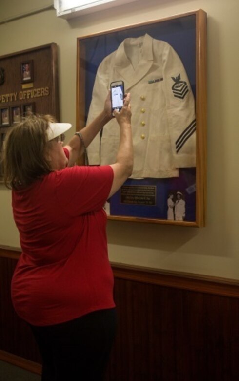 MARINE CORPS BASE HAWAII - A member of John Finn’s family snaps a picture of his Navy dress white uniform during a tour aboard Marine Corps Base Hawaii July 14, 2017. The tour allowed family members to explore the legacy left by Finn after carrying out the feats of heroism that earned himself the first Medal of Honor of WWII. (U.S. Marine Corps Photo by Cpl. Zachary Orr)