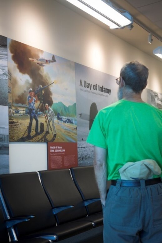 MARINE CORPS AIR STATION KANEOHE BAY - A member of John Finn’s family examines a WWII-era poster of Finn defending his hangar during a tour aboard Marine Corps Base Hawaii, July 14, 2017. The tour allowed family members to explore the legacy left by Finn after carrying out the feats of heroism that earned himself the first Medal of Honor of WWII. (U.S. Marine Corps Photo by Cpl. Zachary Orr)