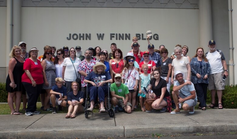 MARINE CORPS BASE HAWAII - The family of John Finn poses for a photo in front of the John Finn Memorial Building at the end of their tour aboard Marine Corps Base Hawaii, July 14, 2017. The tour allowed family members to explore the legacy left by Finn after carrying out the feats of heroism that earned himself the first Medal of Honor of WWII. (U.S. Marine Corps Photo by Lance Cpl. Luke Kuennen)