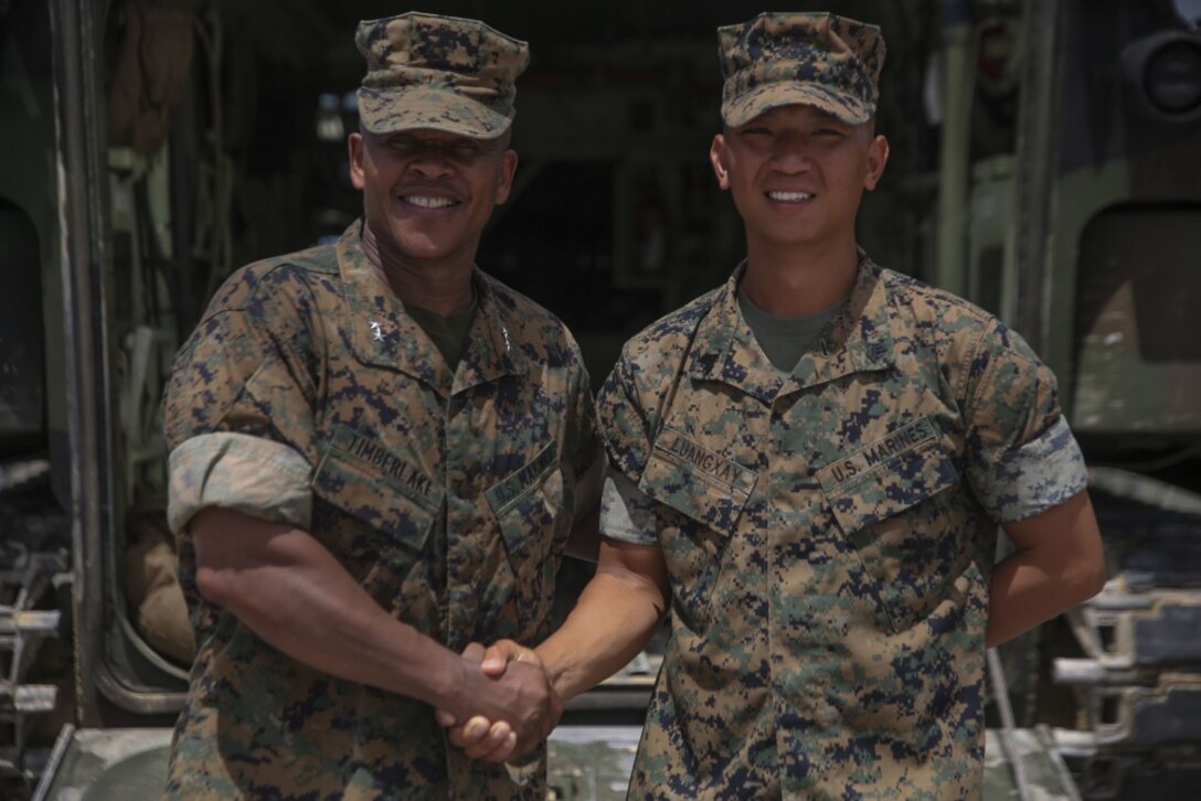 Sgt. Aenoi Luangxay ,right, a squad leader with Combat Engineering Company, 3rd Combat Assault Battalion, 3rd Marine Division, III Marine Expeditionary Force, receives a challenge coin July 7, 2017, in Okinawa, Japan, from Maj. Gen. Craig Timberlake, the 3rd Marine Division commanding officer, for winning the outstanding squad leader award while participating in the 2nd annual Marine Corps Combat Engineer Sapper competition held in Camp Pendleton, California. Luangxay was one of four squad leaders to be in the running for the award.