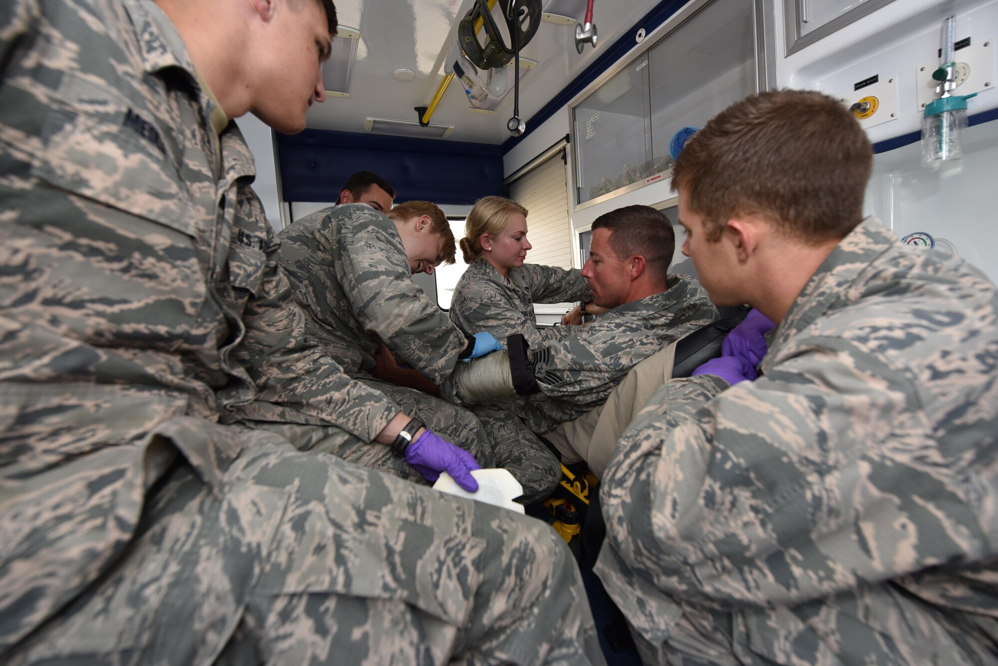 U.S. Air Force Academy cadets practice hemhorrage control techniques on Tech. Sgt. Ryan Folks, 27th Expeditionary Fighter Squadron medical element, in the back of an ambulance at an undisclosed location in southwest Asia, July 6, 2017. Cadets visited the 380th Air Expeditionary Wing and embedded with multiple units across the installation to see firsthand how separate elements of the mission fit into the whole. (U.S. Air Force photo by Staff Sgt. Marjorie A. Bowlden)